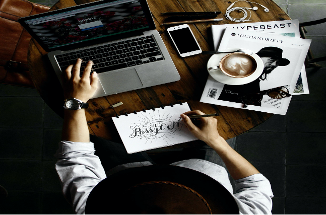 a man doodling on a notebook