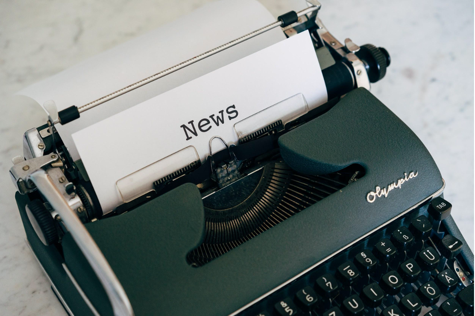 a typewriter with a paper with a heading as news