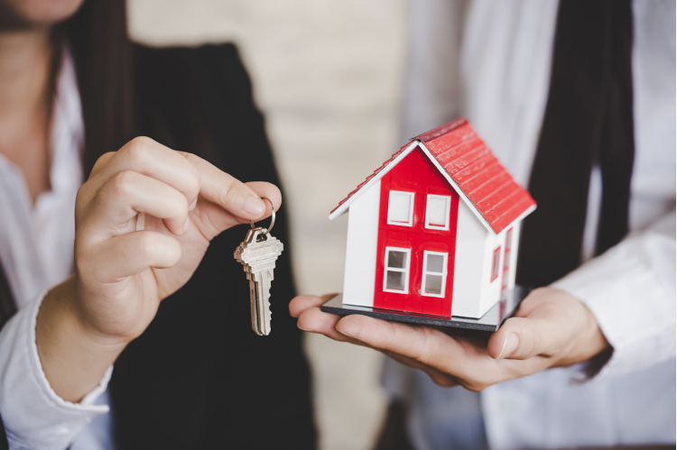 Image of a key and building representing real estate 